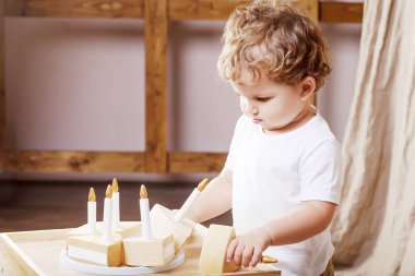 Ahşap oyuncak pasta ile odasında oynayan çocuk çocuk