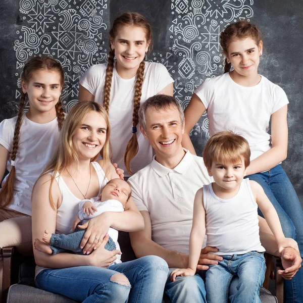 Big family portrait.  Parents with five children. Mother and father with newborn baby, toddler and teenagers. Concept of big happy family