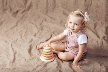 Ahşap oyuncak piramit ile oynayan kız çocuk. Doğal oyuncaklar ile küçük şirin kız.  