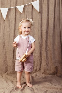 Ahşap oyuncak photocamera ile oynayan kız çocuk. Doğal oyuncaklar ile küçük şirin kız.  
