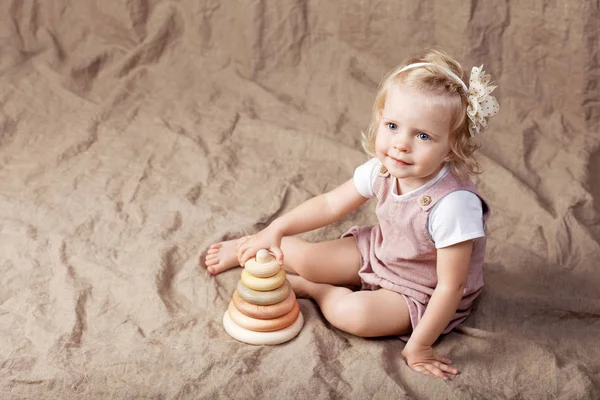 Ahşap oyuncak piramit ile oynayan kız çocuk. Doğal oyuncaklar ile küçük şirin kız.  