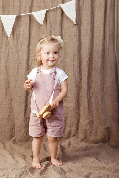 Ahşap oyuncak photocamera ile oynayan kız çocuk. Doğal oyuncaklar ile küçük şirin kız.  