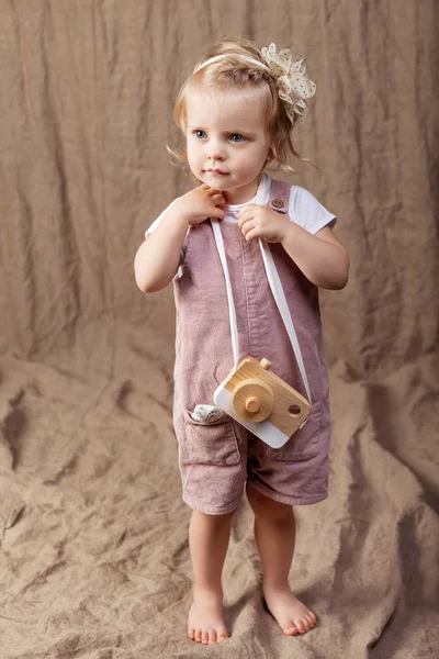 Ahşap oyuncak photocamera ile oynayan kız çocuk. Doğal oyuncaklar ile küçük şirin kız.  