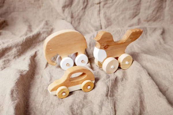 Cute wooden handmade toys for kids on natural linen background. Handcrafted toys