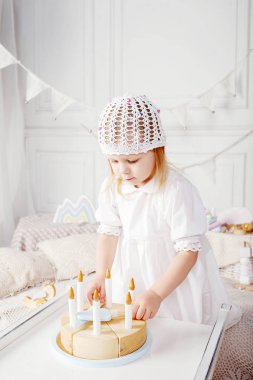 Ahşap oyuncak pastayla oynayan kız çocuk. Doğal oyuncaklar ile küçük şirin kız.