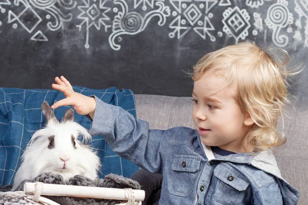 可爱的小男孩玩白兔 男孩微笑着看着镜头 复活节时间 — 图库照片