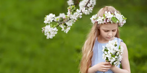 Blosoming リンゴの木のある庭園で青いドレスの美しい少女 かわいい女の子の花の花束を保持しています コピー スペース — ストック写真