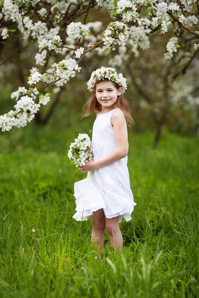 美丽的年轻女孩在白色礼服在花园里与泡泡的苹果树 微笑的女孩有乐趣和享受 — 图库照片