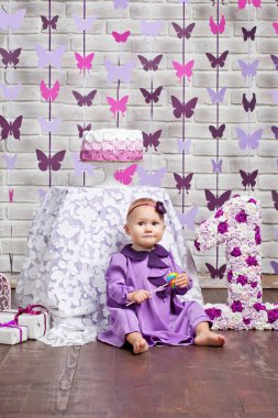 İlk Doğum günü kutluyor mutlu bebek kız. Büyük 1 anf kutusu hediye ile oturan şirin bebek kız