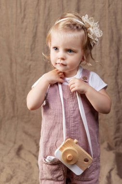 Ahşap oyuncak photocamera ile oynayan kız çocuk. Doğal oyuncaklar ile küçük şirin kız.  