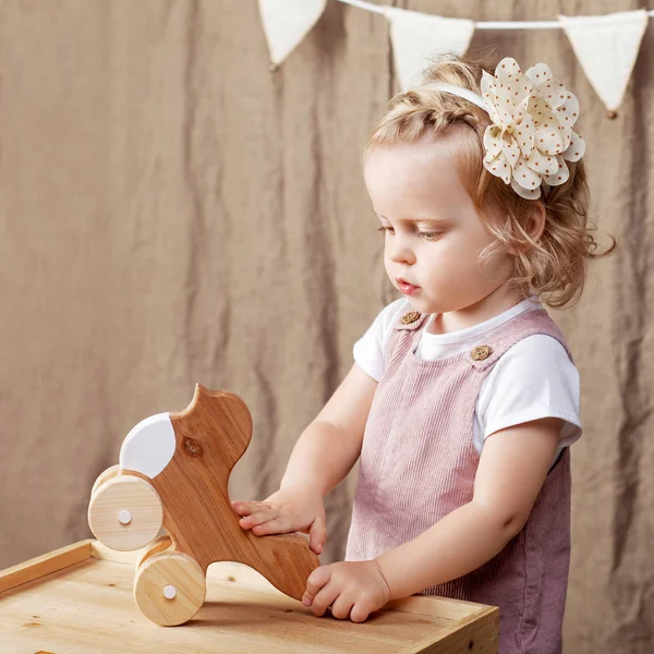 和一只木制玩具鸟玩耍的女孩 小可爱的女孩与自然玩具 — 图库照片
