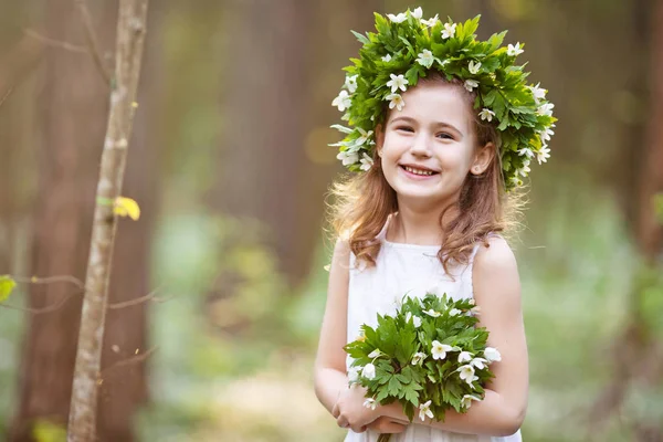 Menina bonita em um vestido branco caminha na madeira de primavera — Fotografia de Stock