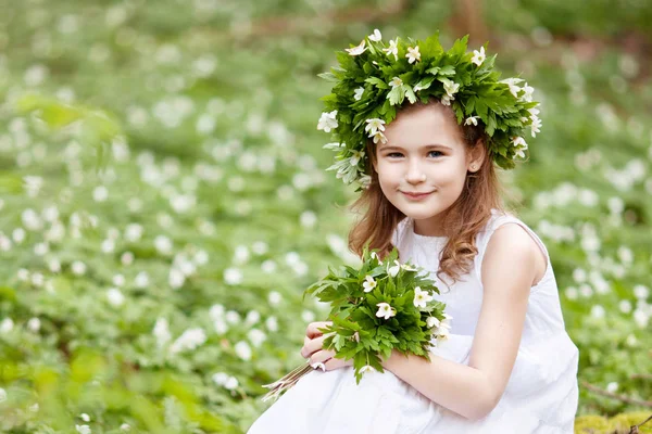 Krásná holčička v bílých šatech procházky v lese na jaře — Stock fotografie