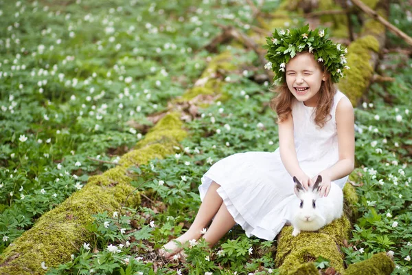 Schöne kleine Mädchen in einem weißen Kleid Flechten mit weißem Kaninchen — Stockfoto