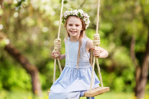 Roztomilá mladá dívka baví na houpačce v rozkvetlé staré apple t — Stock fotografie