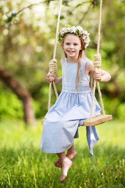 Roztomilá mladá dívka baví na houpačce v rozkvetlé staré apple t — Stock fotografie