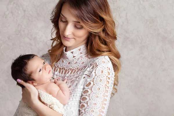 Onun kollarında yeni doğmuş bir bebek tutan güzel kadın. Mot portresi — Stok fotoğraf