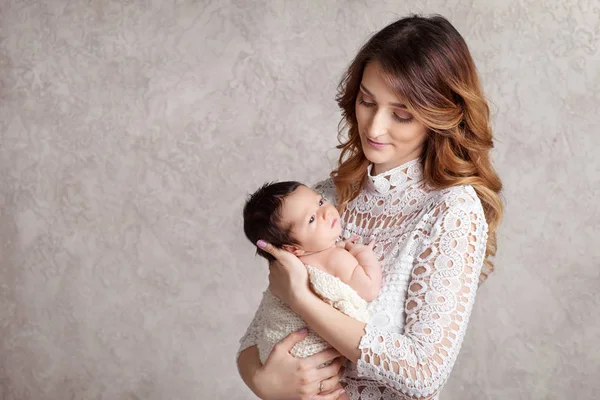 Hübsche Frau hält ein neugeborenes Baby im Arm. — Stockfoto