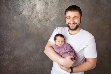 Yeni doğan bebeği elinde tutan baba gülümseyerek. Kavramı 
