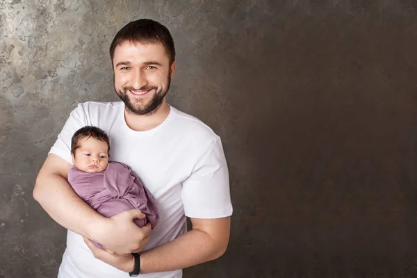 Sonriente padre sosteniendo a su bebé recién nacido en las manos. Concepto de —  Fotos de Stock