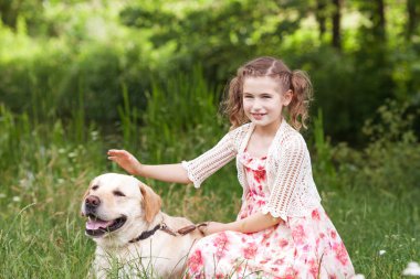 Sevimli gülümseyen küçük kız yaz parkta Labrador sarılma