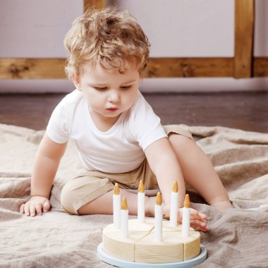 Ahşap oyuncak pasta ile odasında oynayan çocuk çocuk