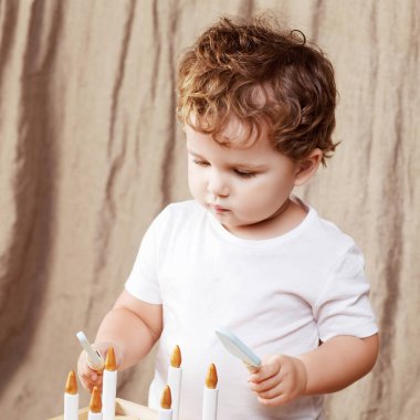 Ahşap oyuncak pasta ile odasında oynayan çocuk çocuk