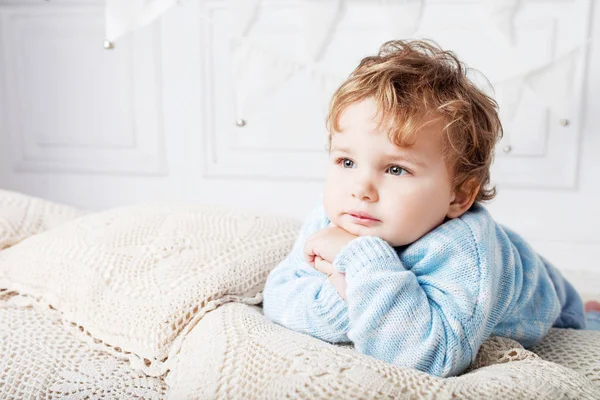 Portret van gelukkig schattig jongetje op het bed in zijn kamer. Thoug — Stockfoto