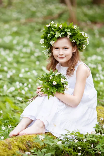 Schönes kleines Mädchen in weißem Kleid spaziert im Frühlingswald — Stockfoto