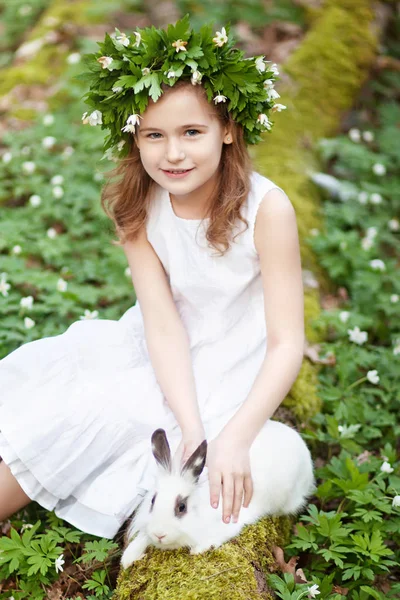 Schöne kleine Mädchen in einem weißen Kleid Flechten mit weißem Kaninchen — Stockfoto