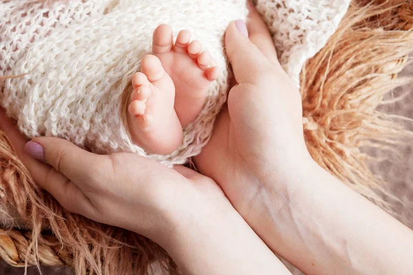 Pies de bebé recién nacidos en manos de madre. Madre sosteniendo las piernas del ki —  Fotos de Stock