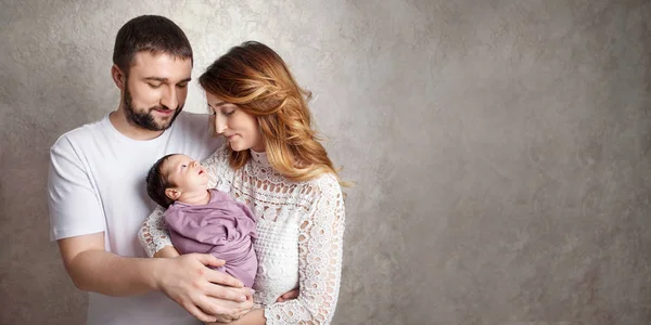 Mujer y hombre sosteniendo a un recién nacido. Mamá, papá y bebé. Retrato de —  Fotos de Stock