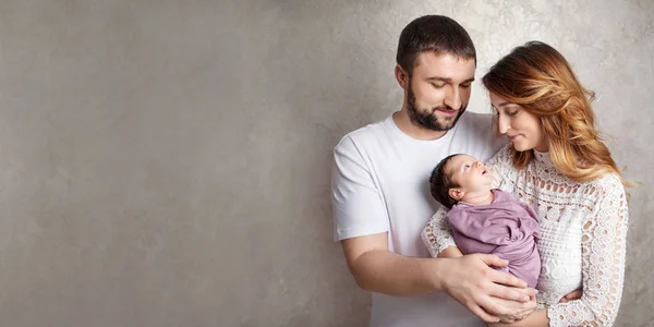 Kadın ve yeni doğmuş bir bebek tutan adam. Anne, baba ve bebek. Portresi