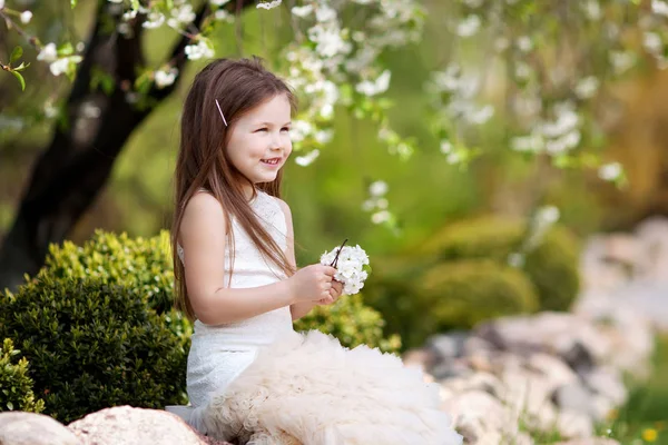 美丽的微笑的小女孩在奶油礼服在开花服装 — 图库照片