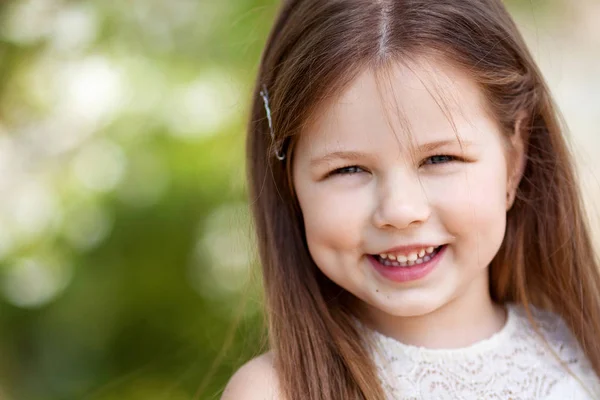 Bela menina sorridente em vestido de creme, contra verde de s — Fotografia de Stock