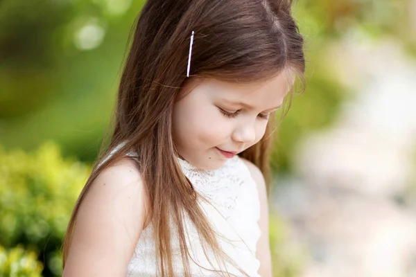 Bela menina sorridente em vestido de creme, contra verde de s — Fotografia de Stock