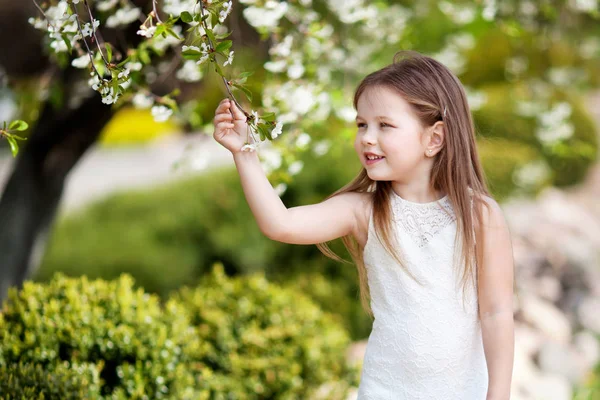 Prettyl sorrindo menina em creme dressin o jardim flor — Fotografia de Stock