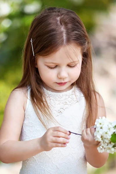 Jolie petite fille en résine crème dans le jardin fleuri — Photo