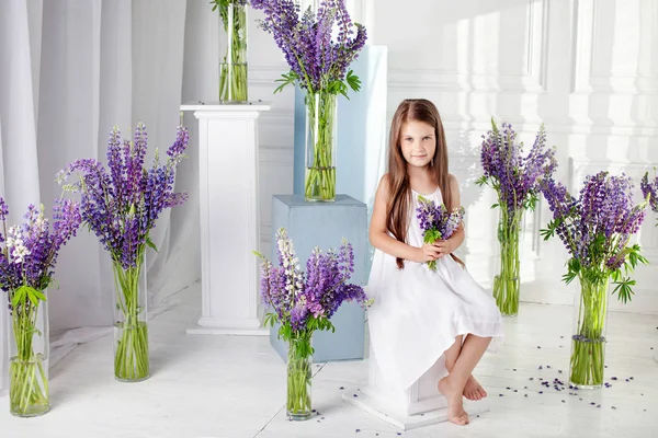 紫の花の間で感情的な美しい少女が座っています。Flo — ストック写真