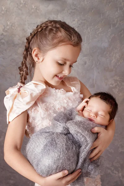 Bebê recém-nascido com irmã. Menina bonito segurando seu irmãozinho . — Fotografia de Stock