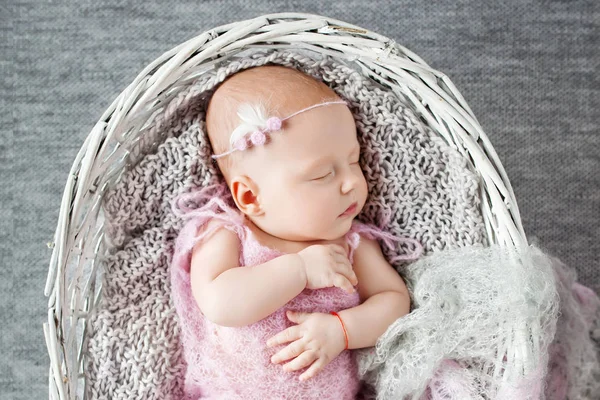 Bela menina recém-nascida dorme em uma cesta wattled — Fotografia de Stock