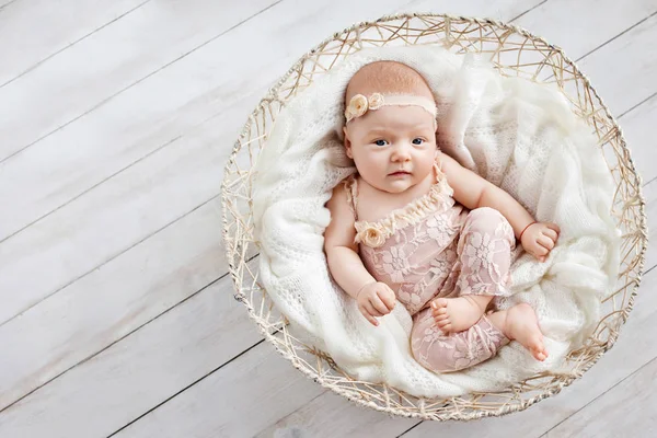 Little newborn baby girl  1 month lying in a wattled basket. Cop — Stock Photo, Image