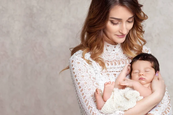 Hübsche Frau mit einem neugeborenen Baby auf dem Arm. mot-Porträt — Stockfoto