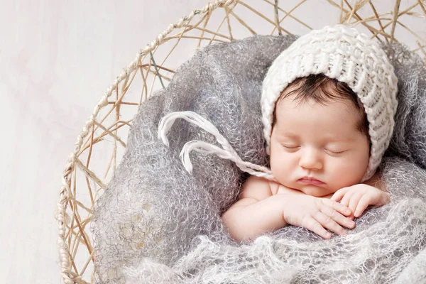 Beautiful little newborn baby 2 weeks sleeping in a basket with knitted plaid. Portrait of pretty newborn baby — Stock Image Beautiful Little Newborn Baby Weeks Sleeping Basket Knitted Plaid Portrait Royalty Free Stock Photos