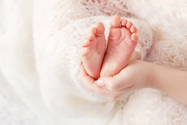 Newborn baby feet in mother hands, shape like a lovely heart. Mo — Stock Photo, Image