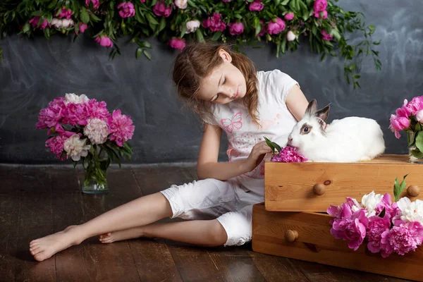 小さな女の子が本物のウサギと遊んで。E 子と白ウサギ — ストック写真