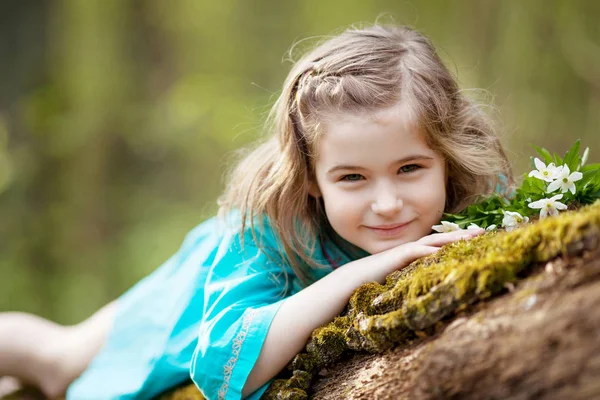 Belle petite fille dans une robe bleue marchant dans le bois de printemps — Photo