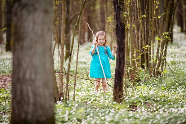 春の森の中を歩く青いドレスの美しい少女 — ストック写真