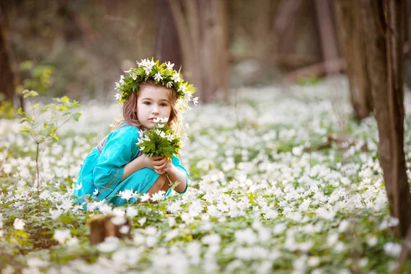 春の森の中を歩く青いドレスの美しい少女 — ストック写真