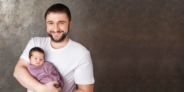 Sonriente padre sosteniendo a su bebé recién nacido en las manos.Familia feliz —  Fotos de Stock